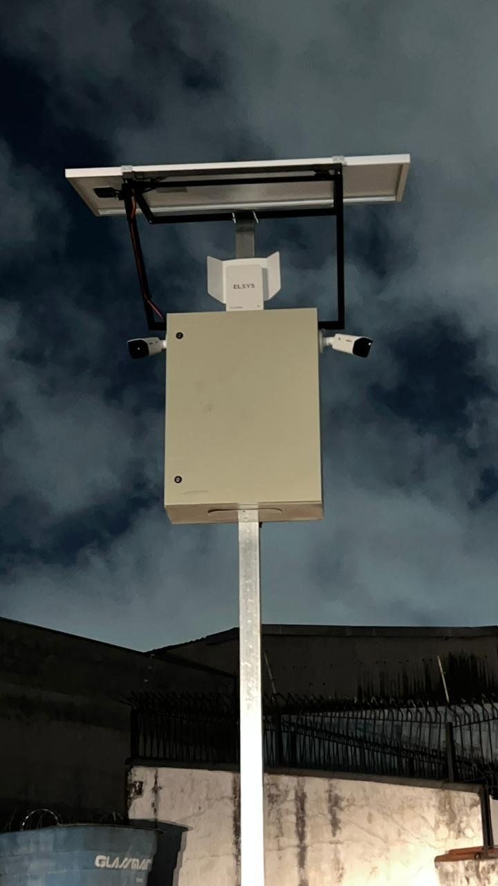Poste de CFTV com painel solar e duas câmeras à noite