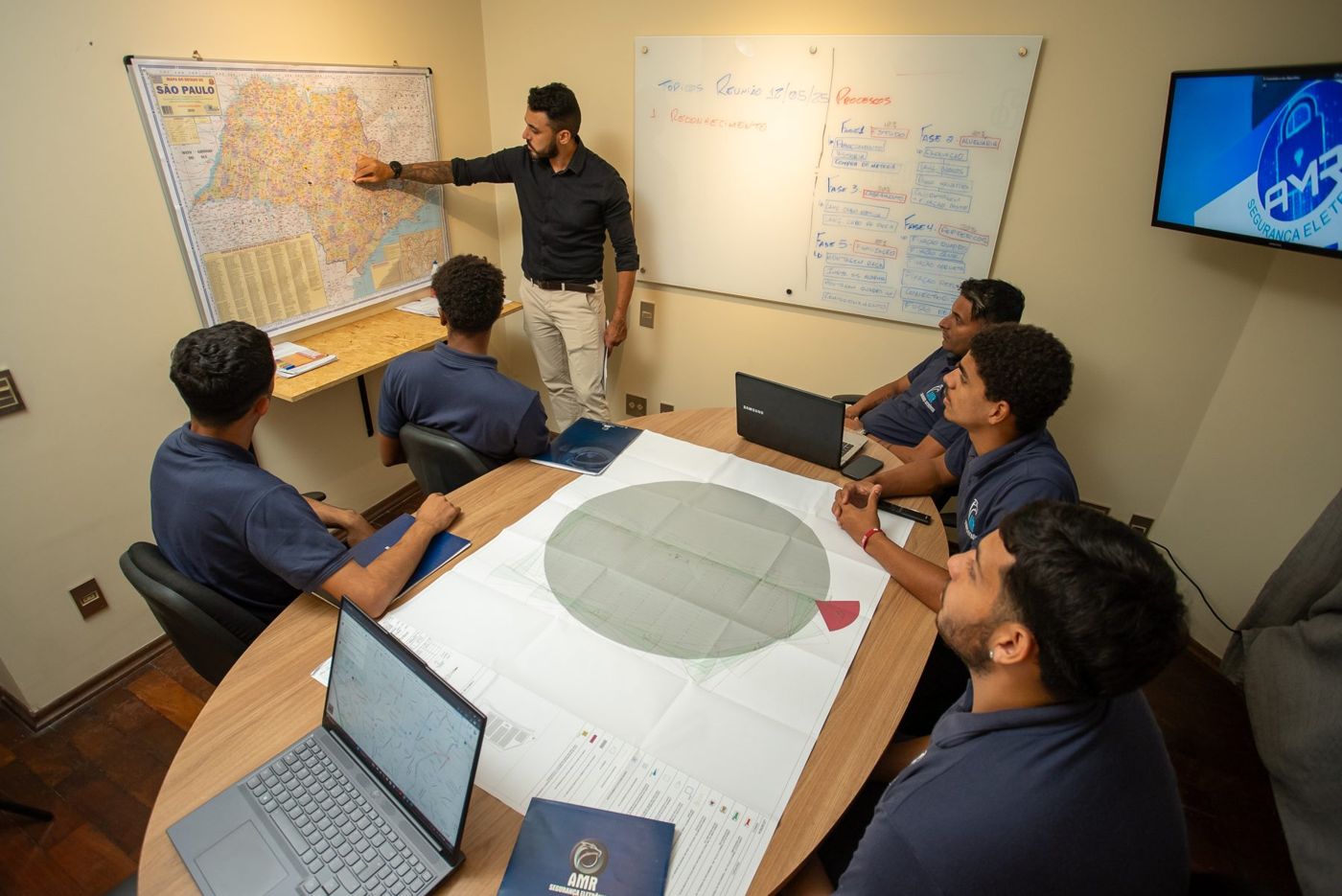 Reunião de planejamento da equipe AMR em frente ao mapa de São Paulo