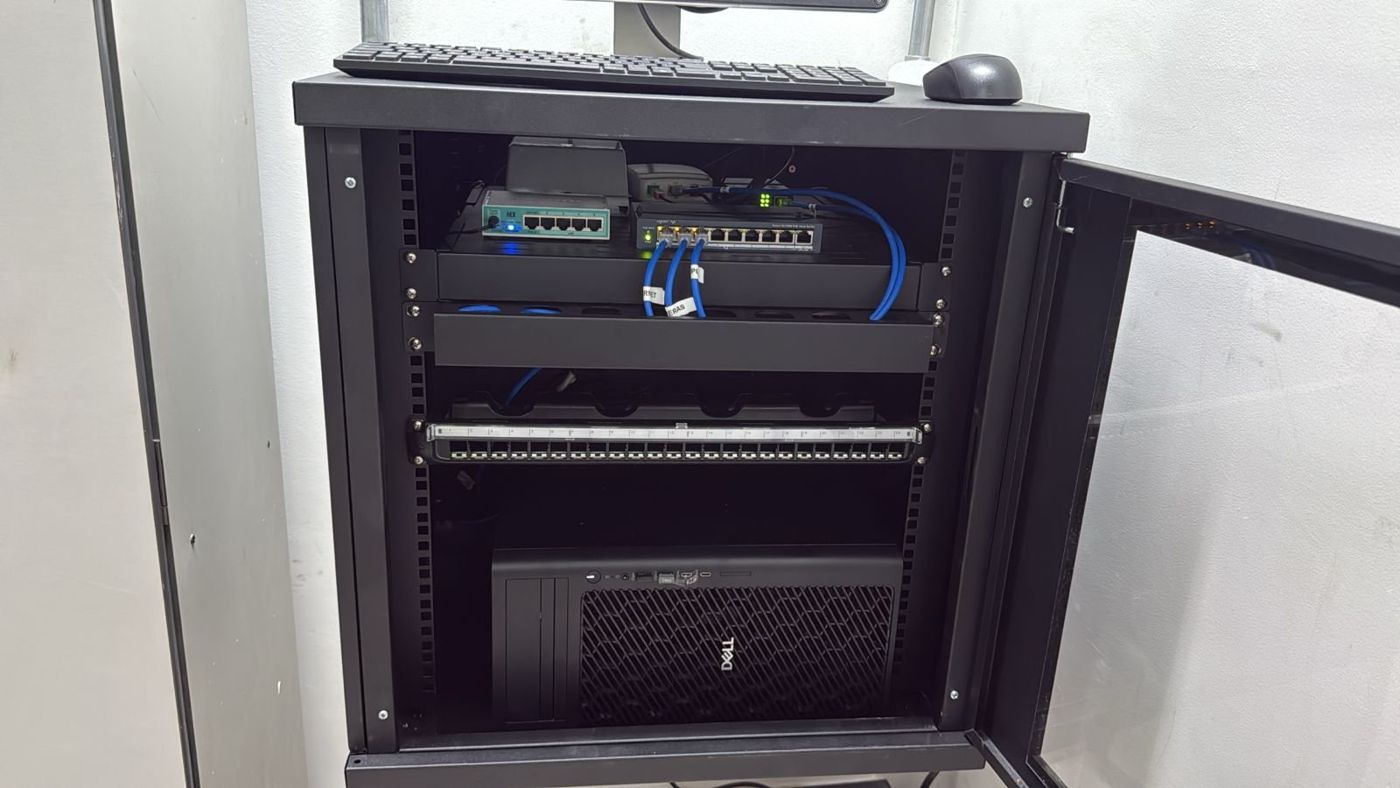 Rack de rede organizado com switches, patch panel e servidor de gravação